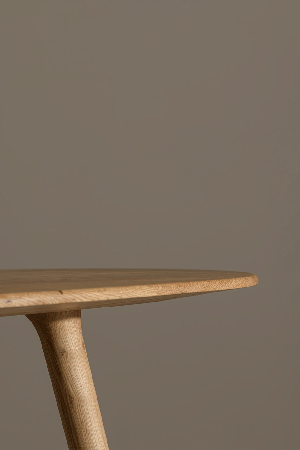 We mill the curved legs directly from the same solid wood as the tabletop. This creates a continuous line that flows from the top through the legs without any sharp corners.