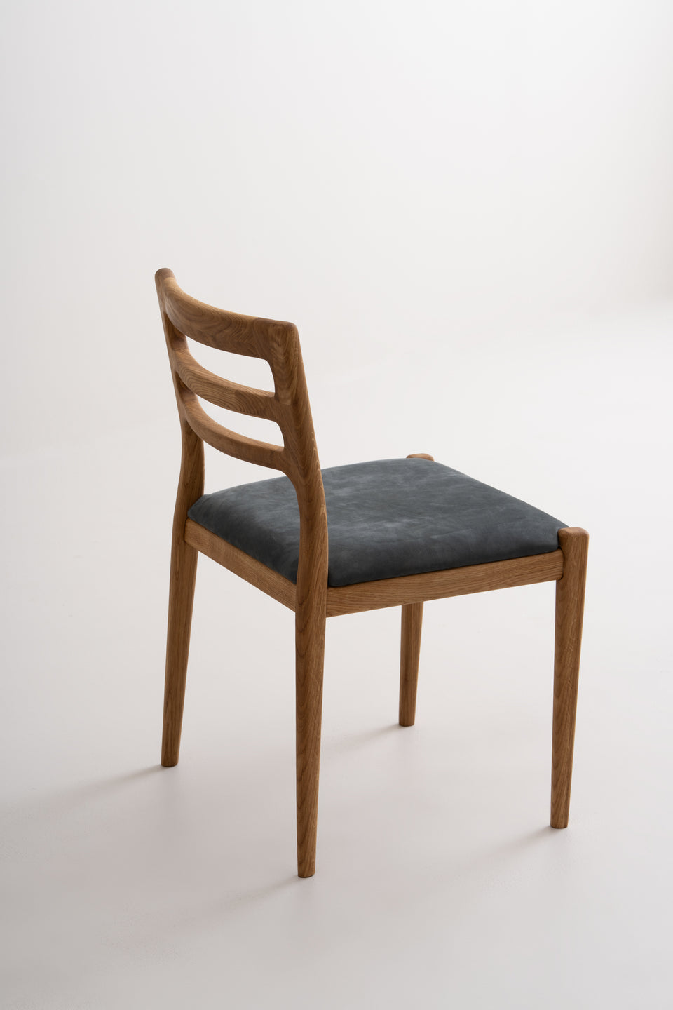 Tapered legs shaped in an oval–square profile for distinction.